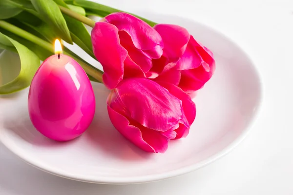 Voorjaar instelling van de tabel met drie roze tulp en kaars ei voor Pasen — Stockfoto