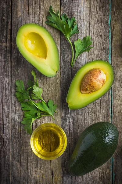 Mat bakgrund med färska ekologiska avokado, lime, persilja och ol — Stockfoto