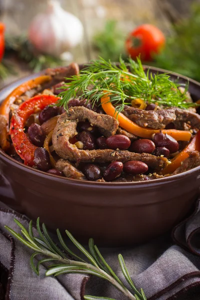 Carne de res con frijol rojo y verduras en maceta sobre fondo rústico — Foto de Stock