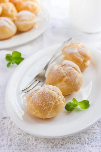 Profiteroles with cream and powdered sugar — Stock Photo, Image