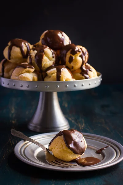 Profiteroles con crema y salsa de chocolate — Foto de Stock