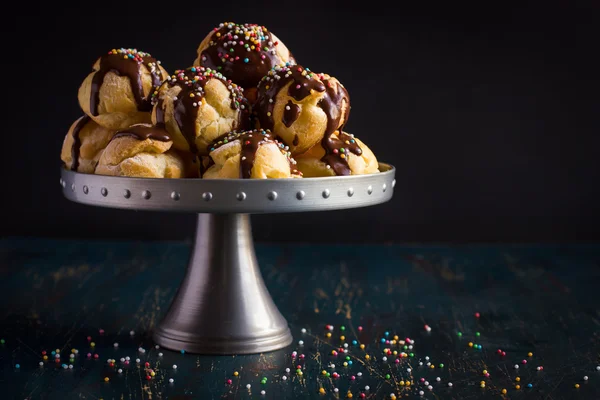 Profiteroles ze śmietaną i kolorowe posypki — Zdjęcie stockowe