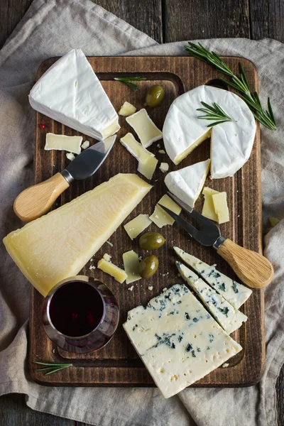 Assortiment van verschillende soorten kaas op een houten bord — Stockfoto