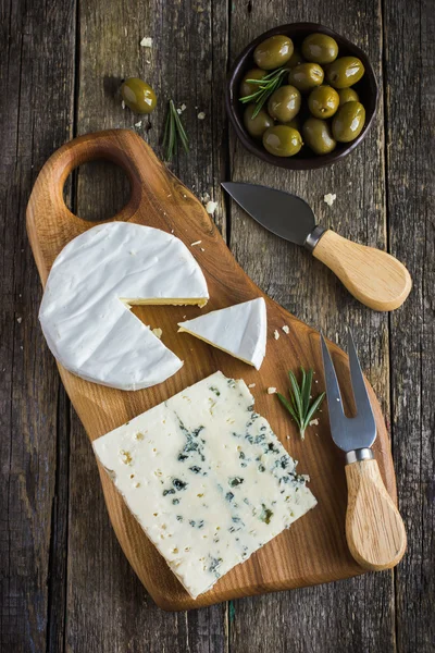 Camembert e queijo azul na tábua de corte — Fotografia de Stock