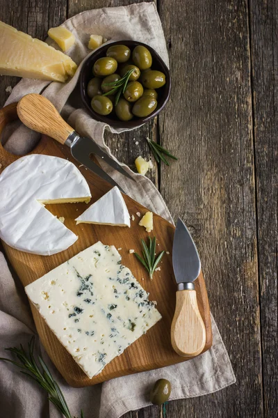 Camembert and blue cheese  on wooden cutting board — Stock Photo, Image