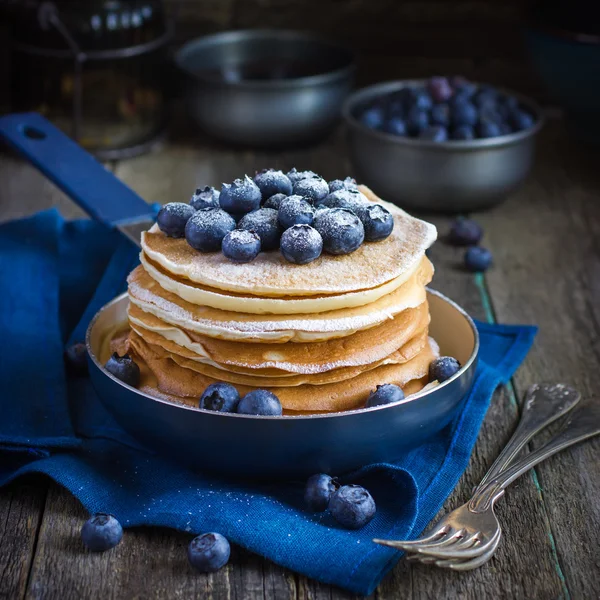 Pancakes with blueberry and powdered sugar in pan — Stock Photo, Image