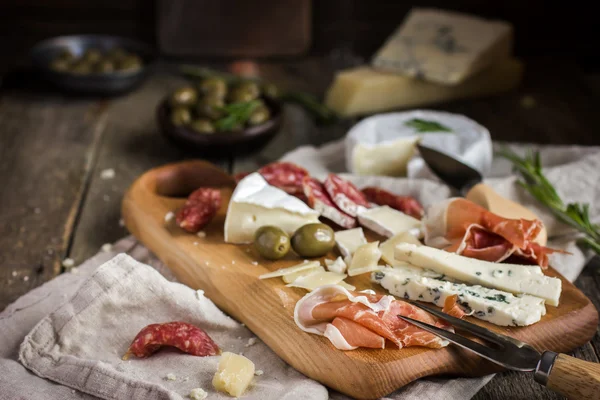 Aperitivos. Varios tipos de queso, salami y jamón en w —  Fotos de Stock