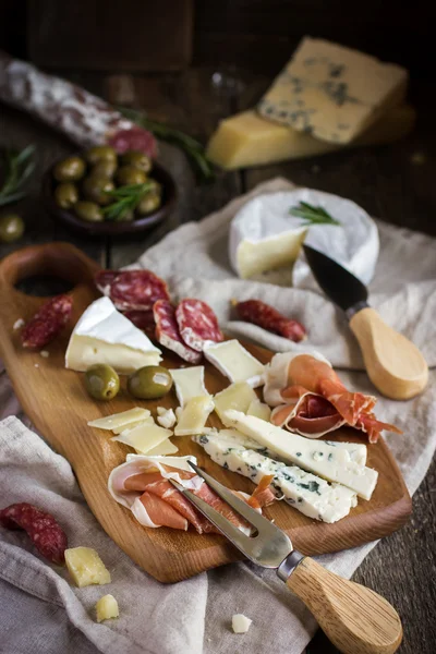 Aperitivos. Varios tipos de queso, salami y jamón en w —  Fotos de Stock