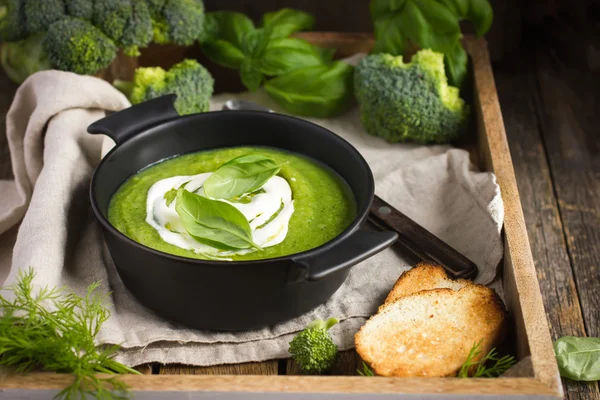 Broccoli cream soup on rustic background — Stock Photo, Image