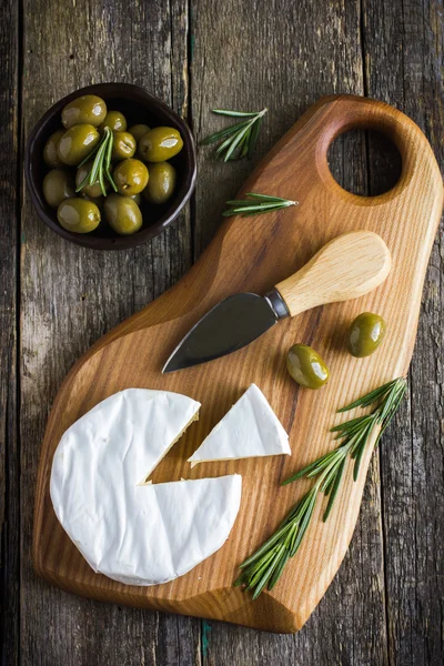 Camembert cheese with rosemary and olives — Stock Photo, Image