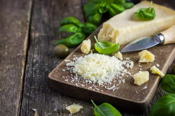 Queijo parmesão sobre tábua de corte de madeira — Fotografia de Stock