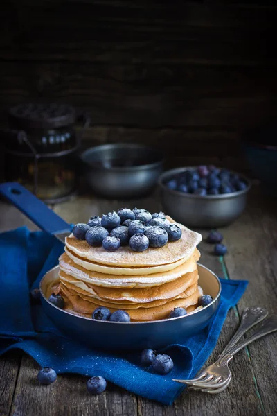 Pancakes with blueberry and powdered sugar in pan — Stock Photo, Image