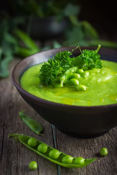 Sopa de ervilha verde no fundo rústico — Fotografia de Stock