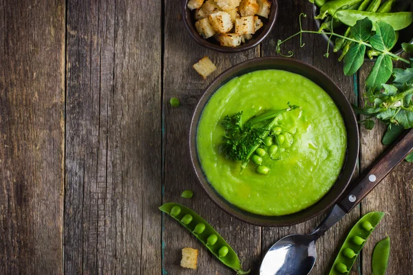 Green peas soup on rustic background — Stock Image Green peas soup on rustic background Stock Photo