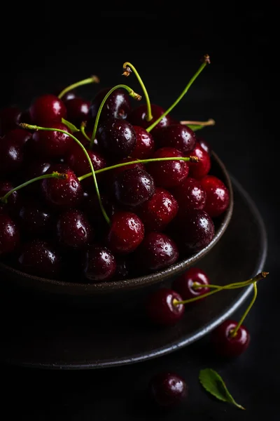 Fresh cherries in black bowl — Stock Photo, Image