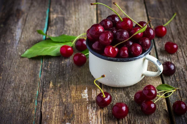 Cerises fraîches dans une tasse en émail — Photo