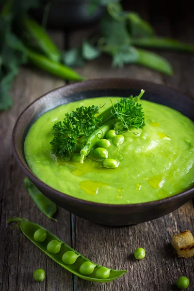 Green pea soup on rustic background — Stock Photo, Image