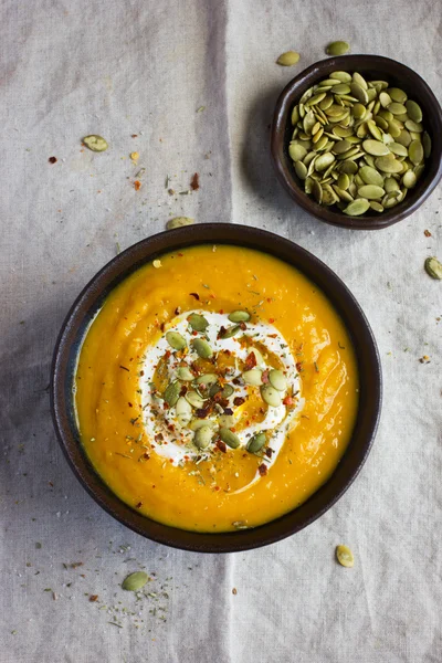 Soupe à la citrouille avec des graines de citrouille sur un bol — Photo