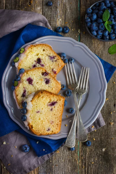 Three slices of blueberry cake with sugar icing and fresh berrie — Stock Photo, Image