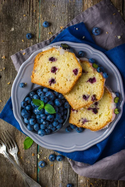 Three slices of blueberry cake with sugar icing and fresh berrie — Stock Photo, Image