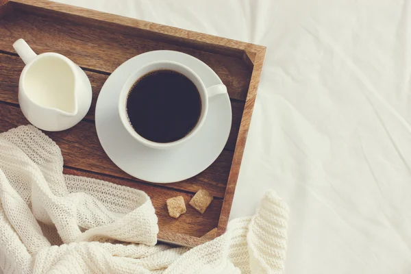 Kopp kaffe, grädde och brunt socker på trä bricka — Stockfoto