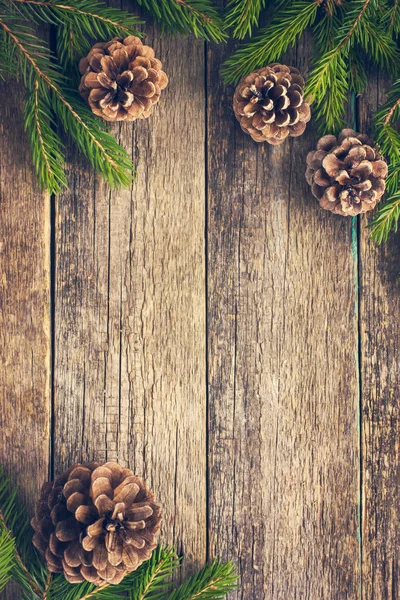 Fir branches and pine cones on wooden background — Stock Photo, Image