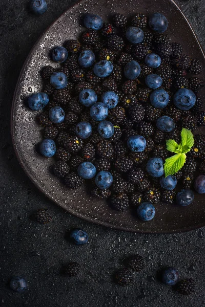 Fresh blackberry and blueberry on black plate. — Stock Photo, Image