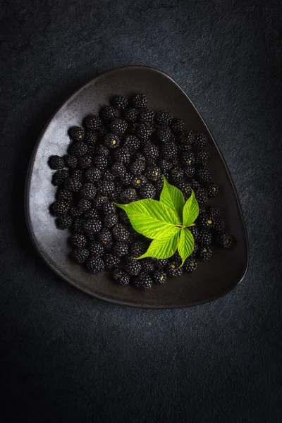 Zarzamora fresca y hoja verde sobre plato negro —  Fotos de Stock