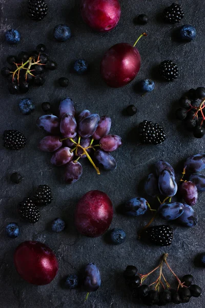 Frische dunkle Früchte und Beeren auf schwarzem Hintergrund. — Stockfoto