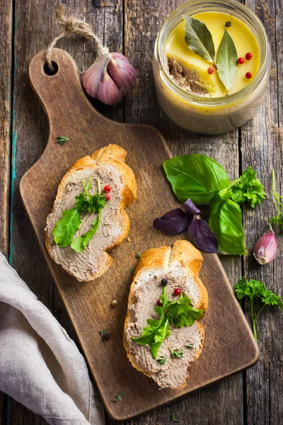 Bread with chicken liver pate on wooden cutting board — Stock Photo, Image