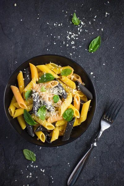 Colorful penne pasta  with parmesan cheese and basil — Stock Photo, Image