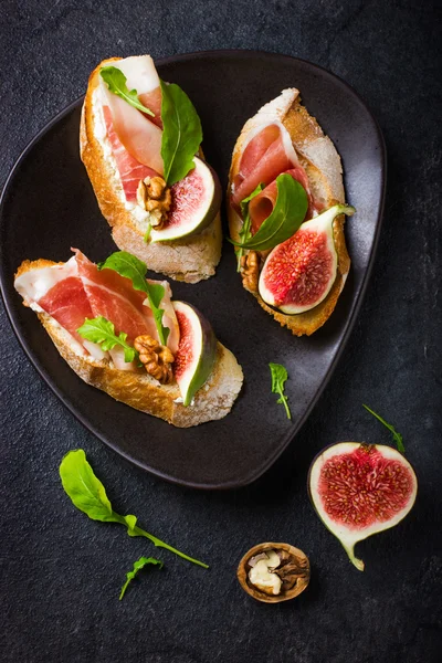 Bruschetta z kozim serem, figi, prosciutto i rukolą — Zdjęcie stockowe