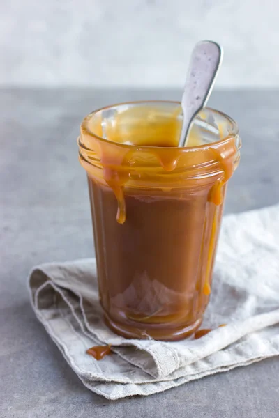Zelfgemaakte gezouten karamel saus op glazen pot — Stockfoto