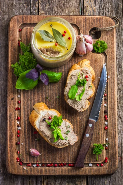 Bread with chicken liver pate on wooden cutting board — Stock Photo, Image