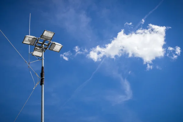 Industriële schijnwerper met blauwe hemelachtergrond en wolken — Stockfoto