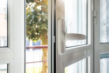 Alüminyum pencere açık. Alt pencerede. Metal, PVC kapı çerçevesi yakın çekim görüntüsü. Kaliteli krom saplı. Enerji tasarrufu ve güvenlik profili. Kentsel bulanık arkaplan.