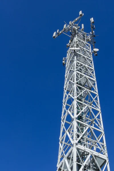 Vista inferior de una torre de comunicaciones con cielo azul en el fondo . —  Fotos de Stock