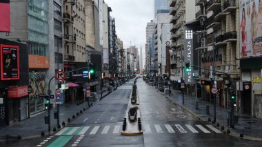 Buenos Aires, Arjantin 'in Buenos Aires şehir merkezindeki boş bir caddenin geniş açıyla görüntüsü. Olay yerinde dükkanlar ve konut birimleri de dahil olmak üzere yüksek binalar yer alıyor.