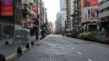 Buenos Aires, Arjantin 'in Buenos Aires şehir merkezindeki boş bir caddenin geniş açıyla görüntüsü. Olay yerinde dükkanlar ve konut birimleri de dahil olmak üzere yüksek binalar yer alıyor.