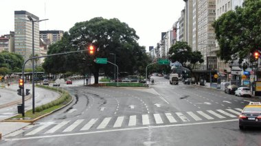 Buenos Aires, Arjantin 'in Buenos Aires şehir merkezindeki boş bir caddenin geniş açıyla görüntüsü. Olay yerinde dükkanlar ve konut birimleri de dahil olmak üzere yüksek binalar yer alıyor.