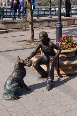 Budapeşte (Macaristan). Budapeşte 'de Tuna nehrinin yanında köpeğiyle duran bir kız heykeli.