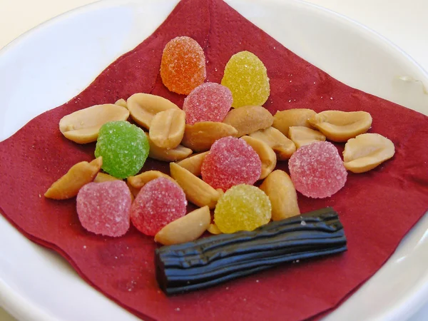 Pequeño plato con gominolas, cacahuetes — Foto de Stock