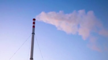 Mavi gökyüzünde beyaz dumanlı uzun kule borusu