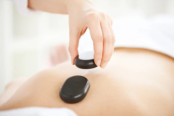 Woman having hot stones on her back — Stock Photo, Image