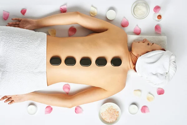 Woman with stones on her back — Stock Photo, Image