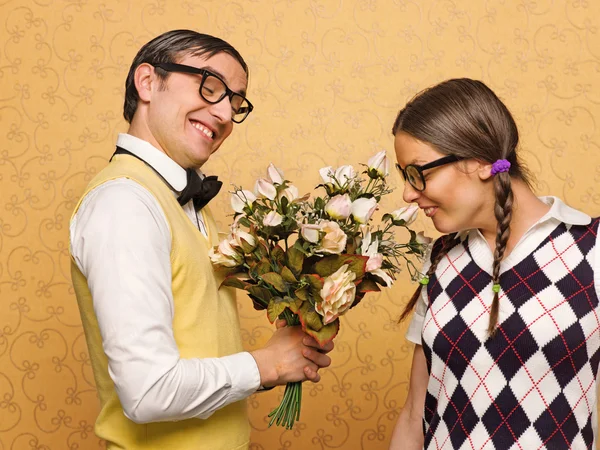 Man nörd att ge blommor till sin flickvän — Stockfoto