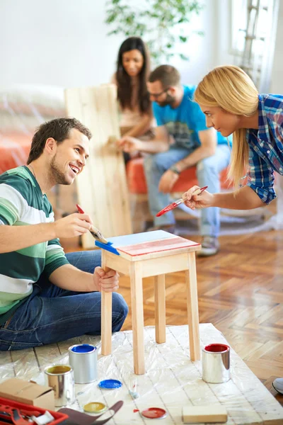 Young couple painting furniture at home — Stock Photo, Image