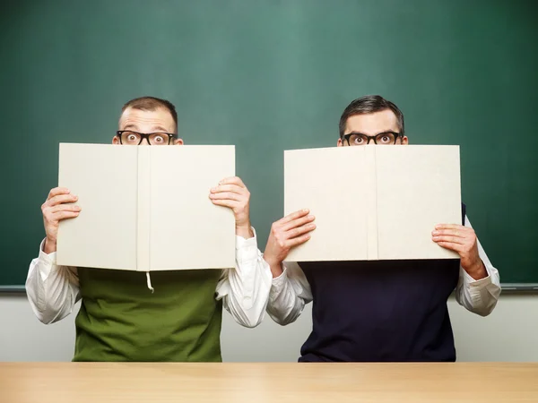 Männliche Nerds bedeckten Gesichter mit Büchern — Stockfoto