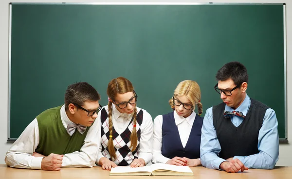 Vier nerds lezen van boek — Stockfoto