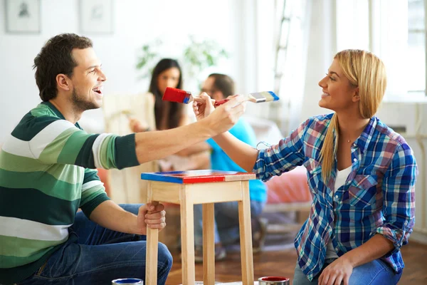 Jovem casal pintura mobiliário em casa — Fotografia de Stock